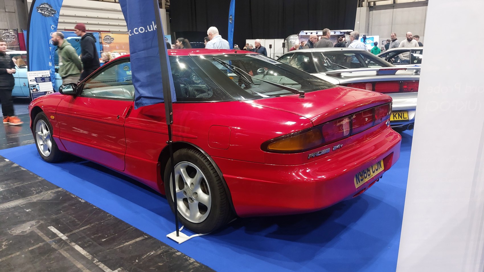 Red sports coupe with sleek rear side profile and distinct lights