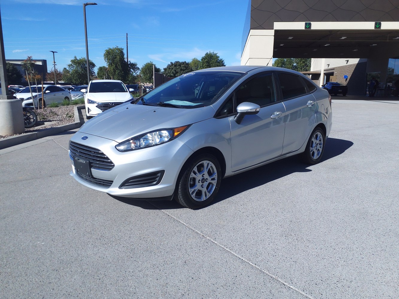 Compact silver sedan with modern headlights and sleek grille