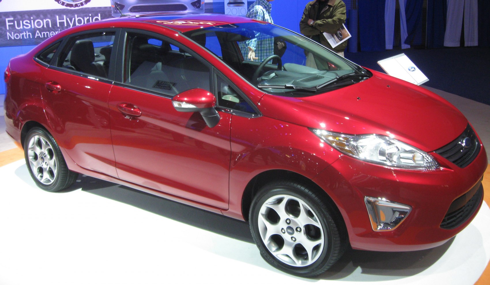 Red compact sedan with sleek design and five-spoke alloy wheels