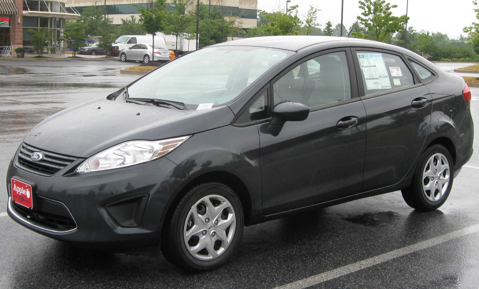 Black sedan front side view with headlight and alloy wheel