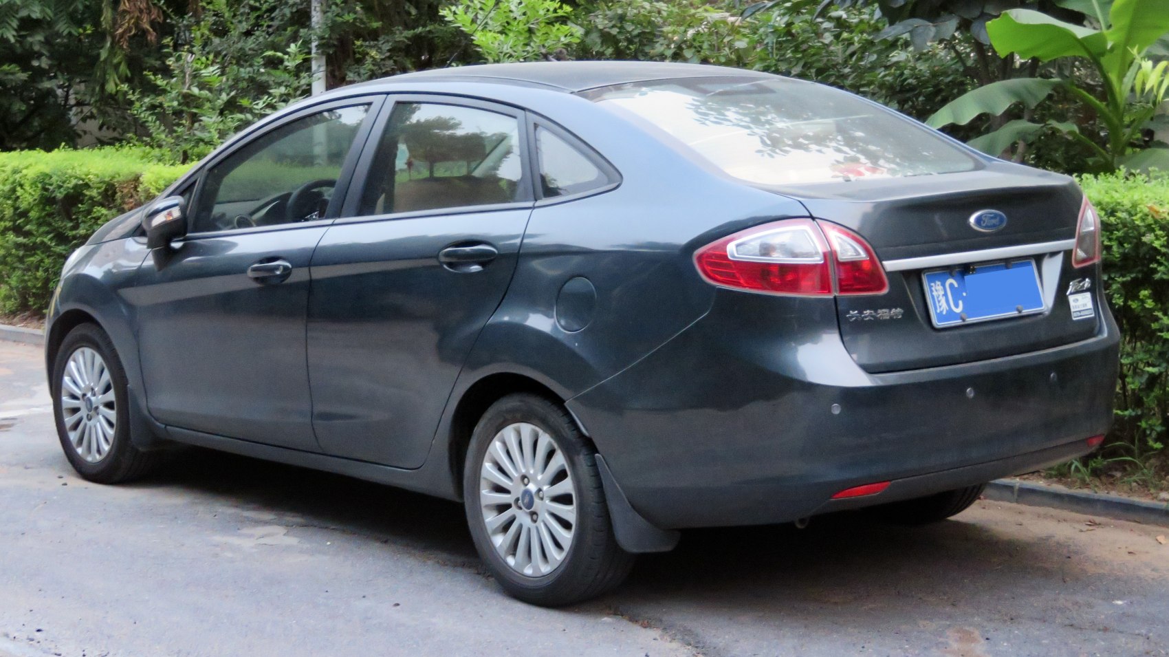 Rear side view of compact 4-door sedan with stylish taillights.