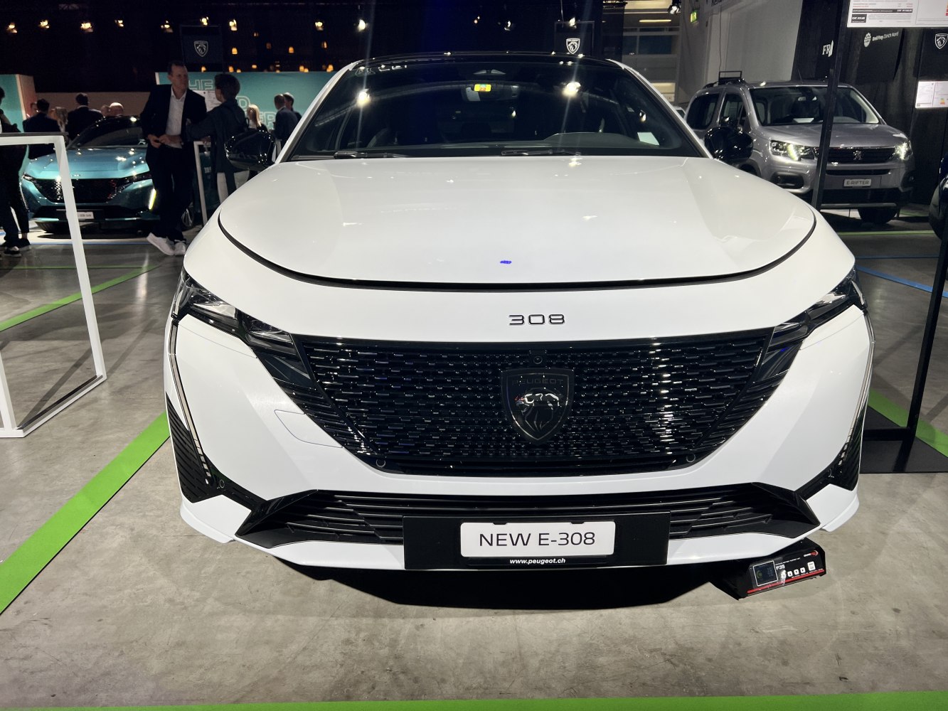 White car front with a prominent black grille and sharp modern headlights