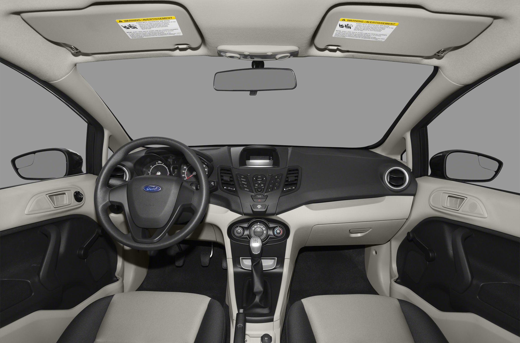 Car interior with dashboard, steering wheel, and manual transmission