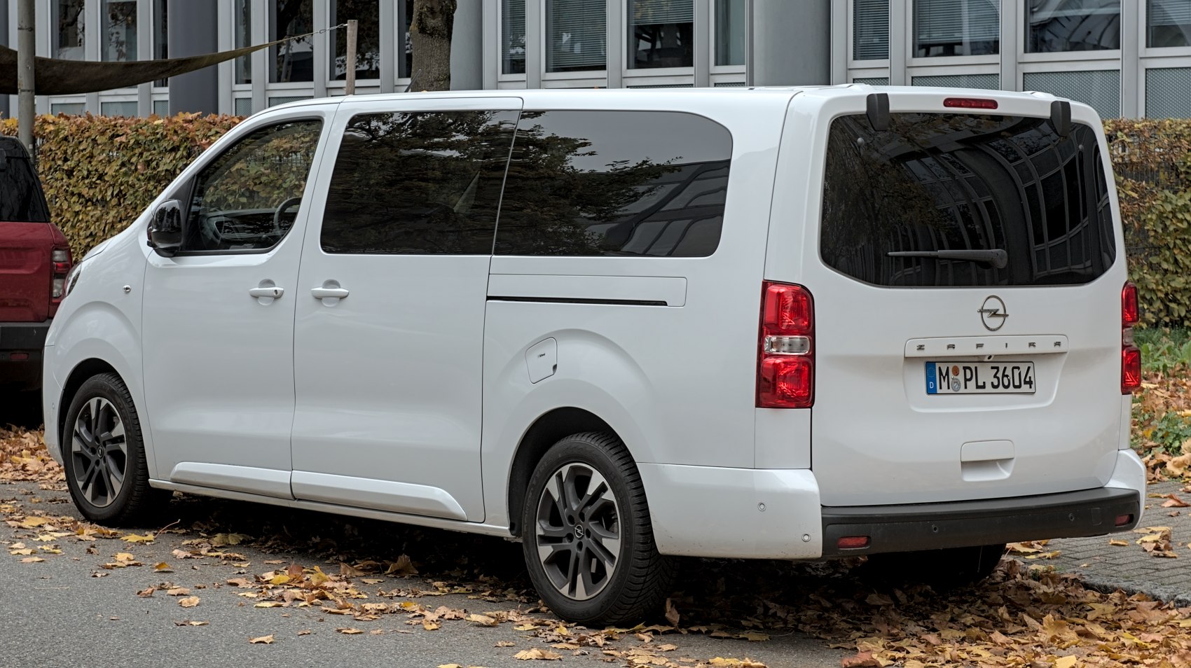 Rear side view of white van with tinted windows and sliding door