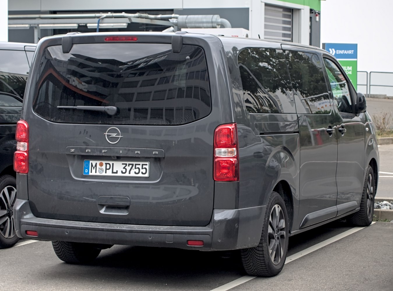Rear view of a large passenger van with tinted windows and vertical taillights