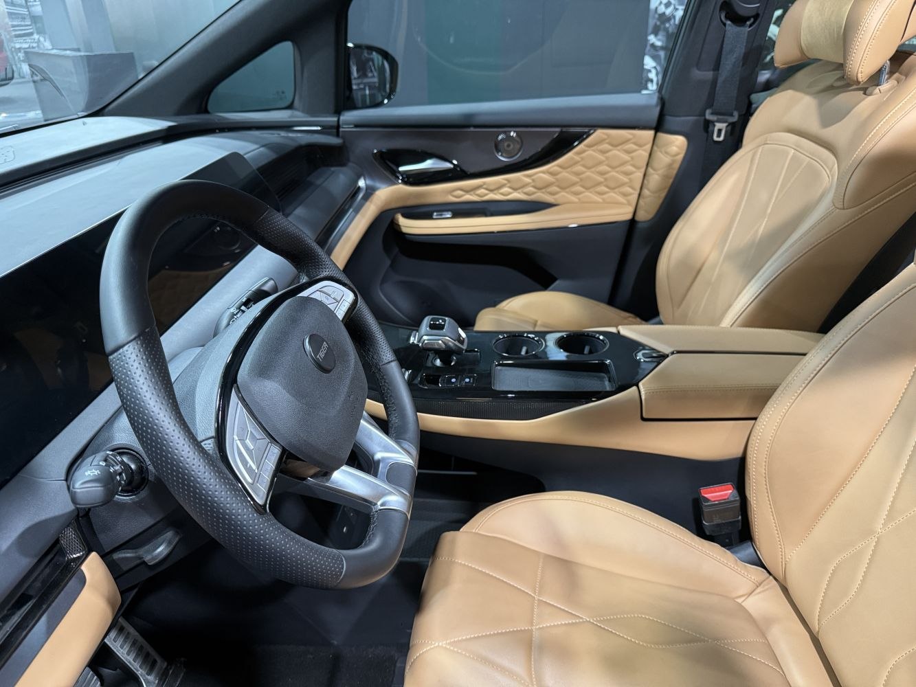 Beige leather seats and modern steering wheel in a refined car interior