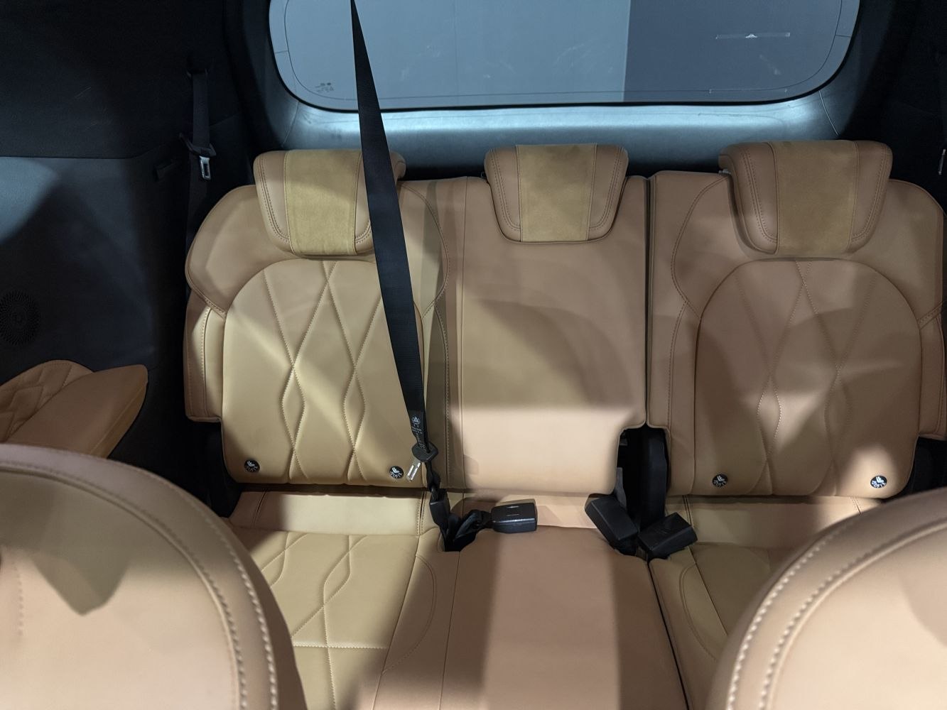 Beige leather rear seats with headrests and seat belts