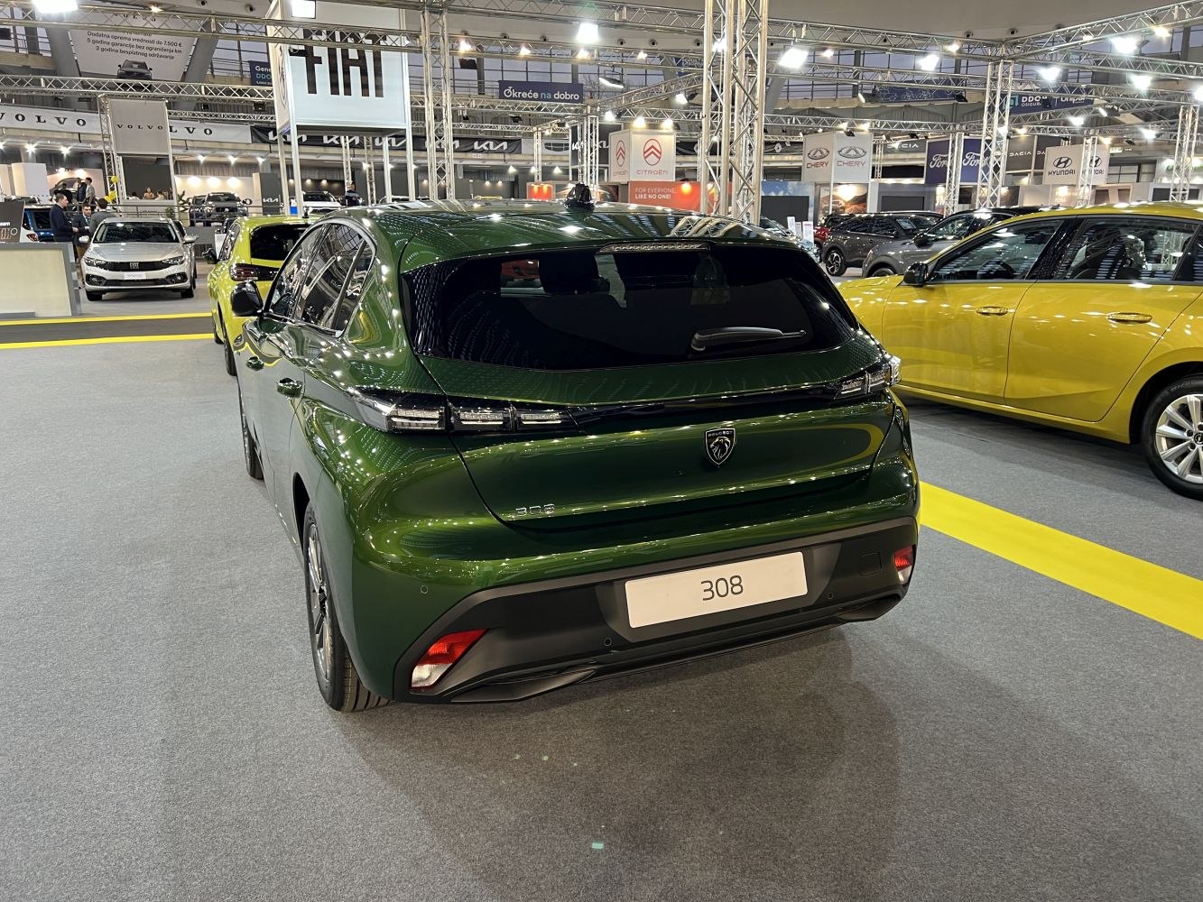 Rear view of a green hatchback with modern horizontal taillights and smooth aerodynamic lines