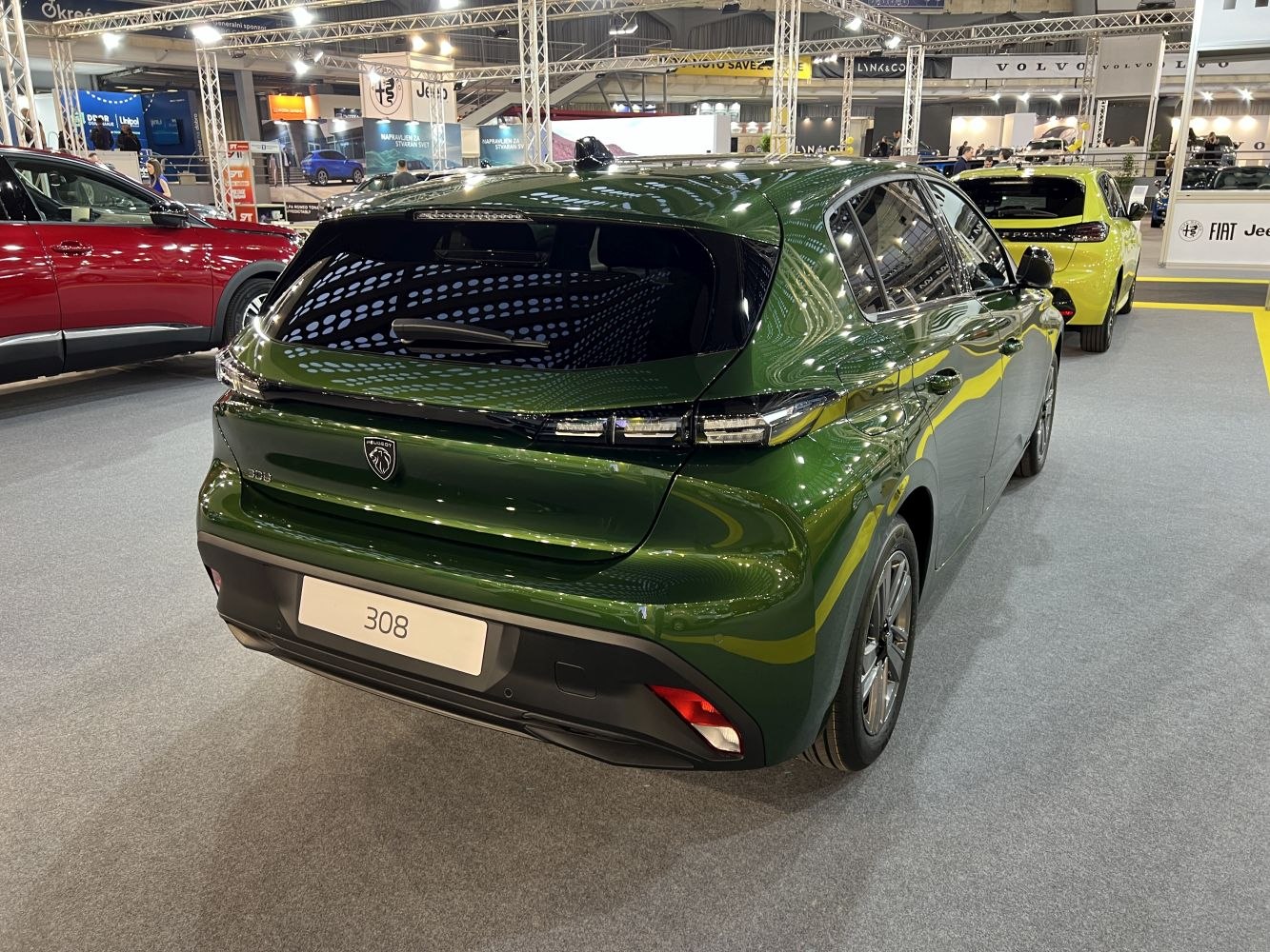 Rear view of modern hatchback with sleek taillights and reflective green paint