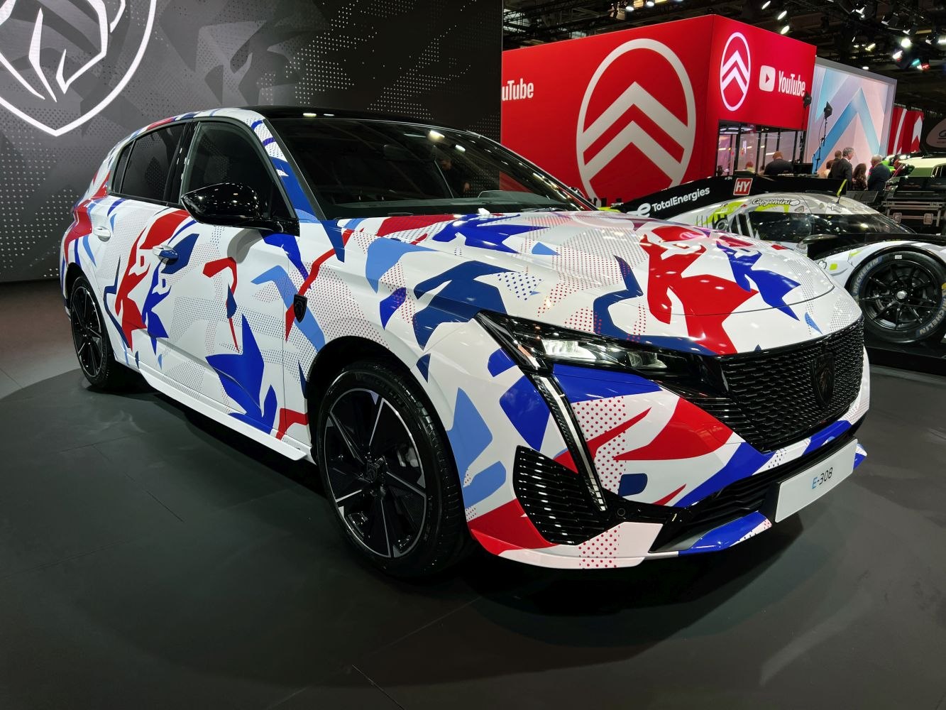 Modern hatchback with unique red, white, and blue abstract pattern and black alloy wheels