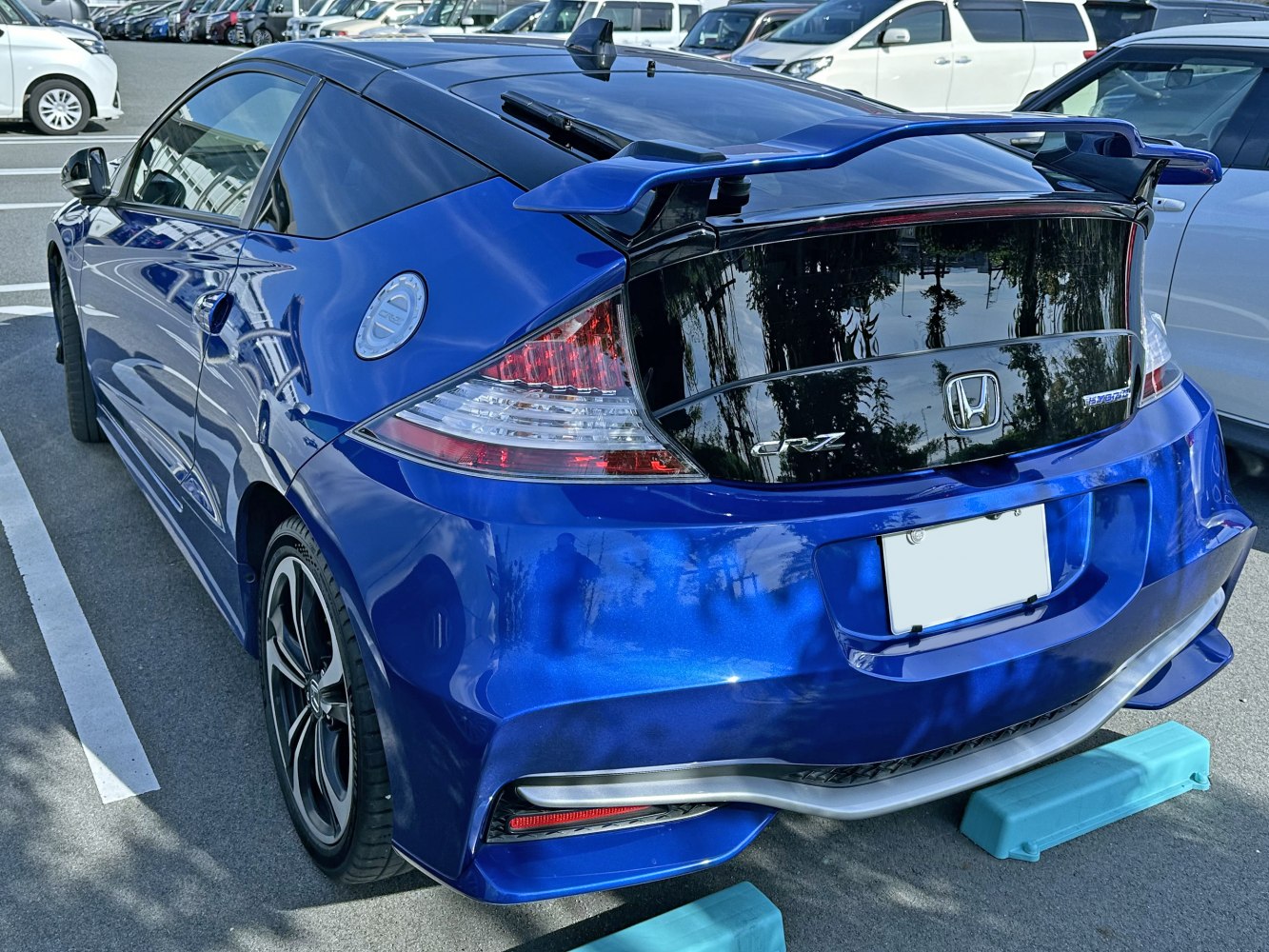 Rear view of sporty compact hatchback with spoiler and hybrid badge