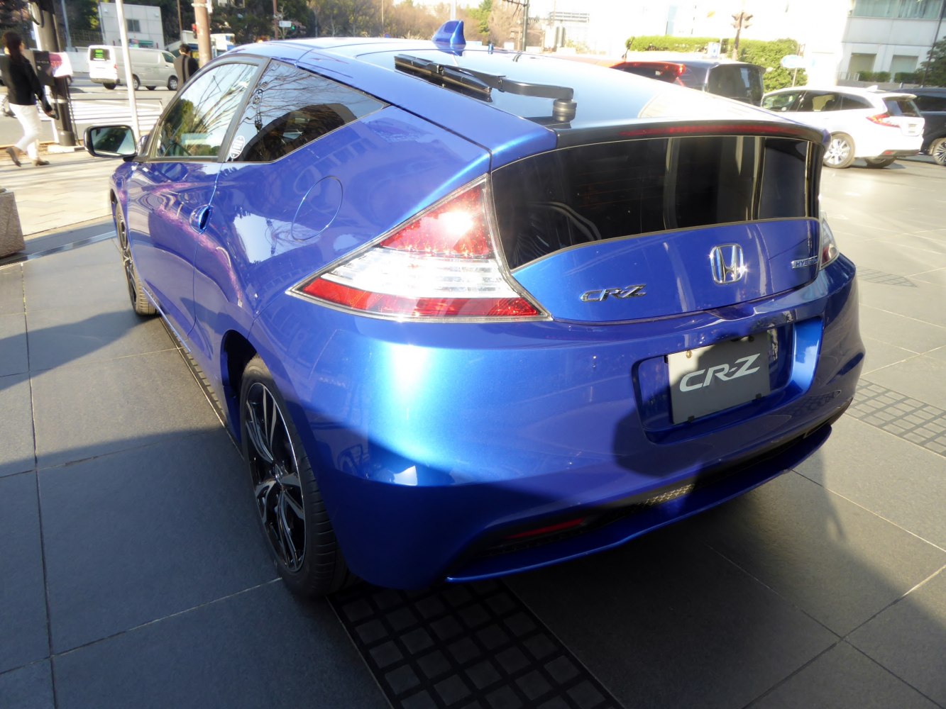 Rear view of a blue compact hybrid with distinct taillights and hybrid badge