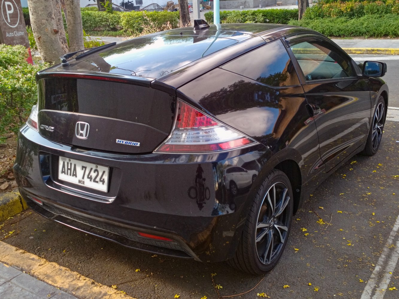 Rear view of a black hybrid hatchback with distinctive taillights and alloy wheels