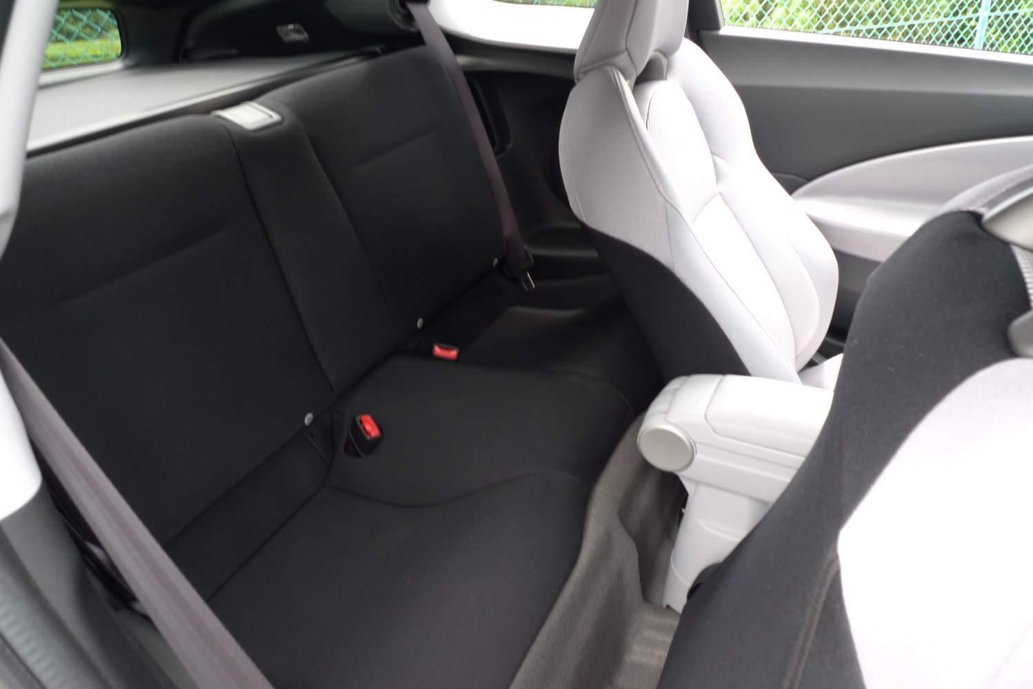 Compact black rear seats with modest legroom and sporty front seats