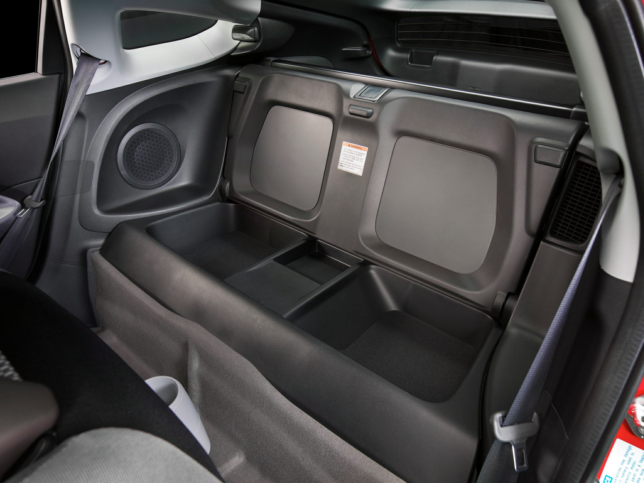 Compact rear storage with integrated speakers and seatbelt