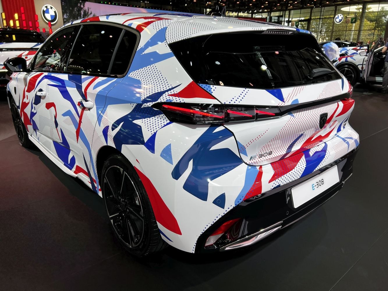 Rear hatchback view with multicolor camouflage paint and distinctive taillights
