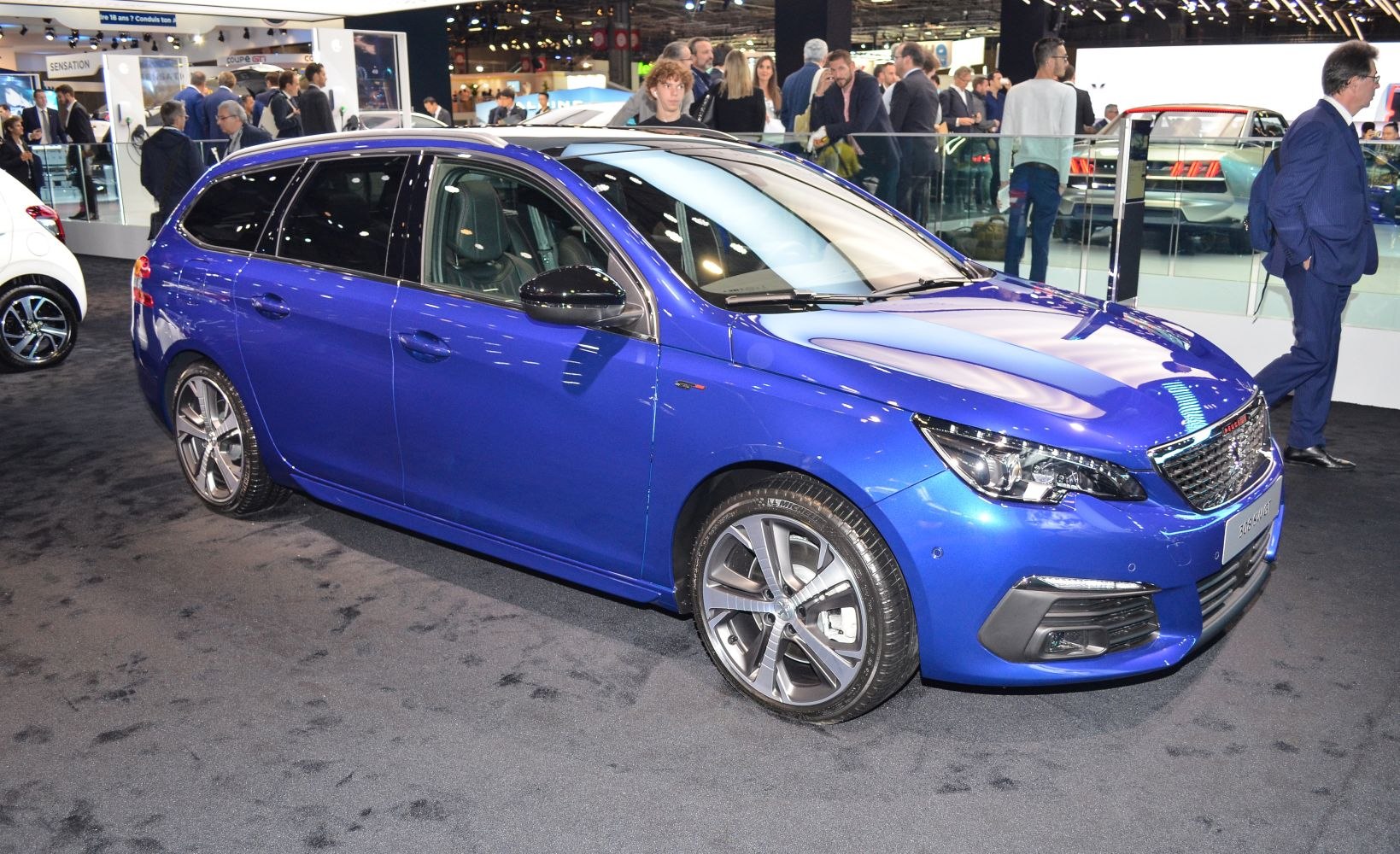 Blue compact station wagon with alloy wheels at auto show