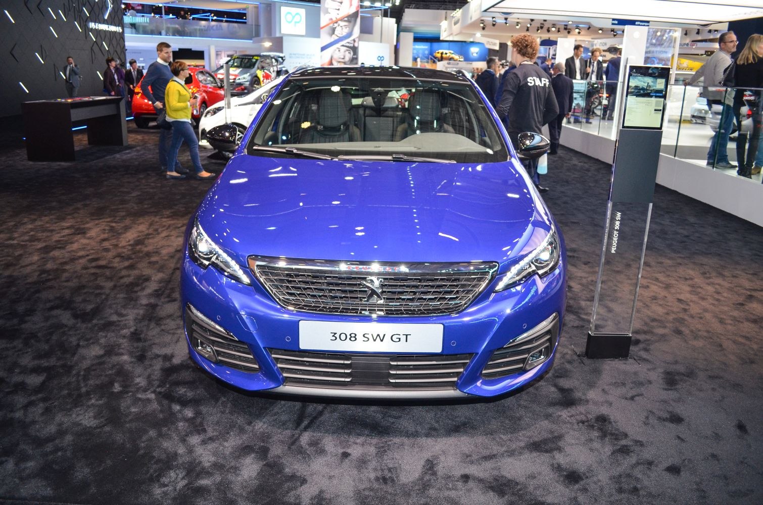 Blue vehicle front with prominent grille and sleek headlights