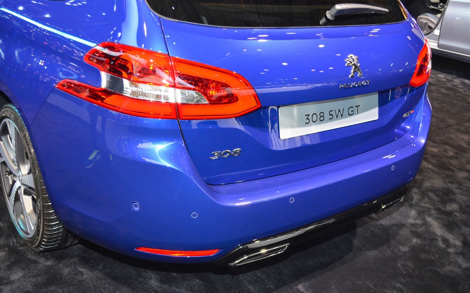 Close-up of rear taillight and badge on blue vehicle.