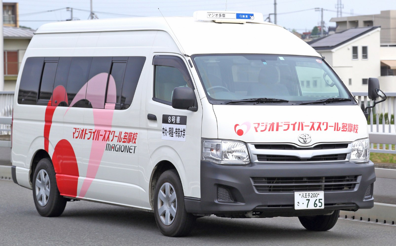 Front and side view of a commuter van with tinted windows and exterior graphics