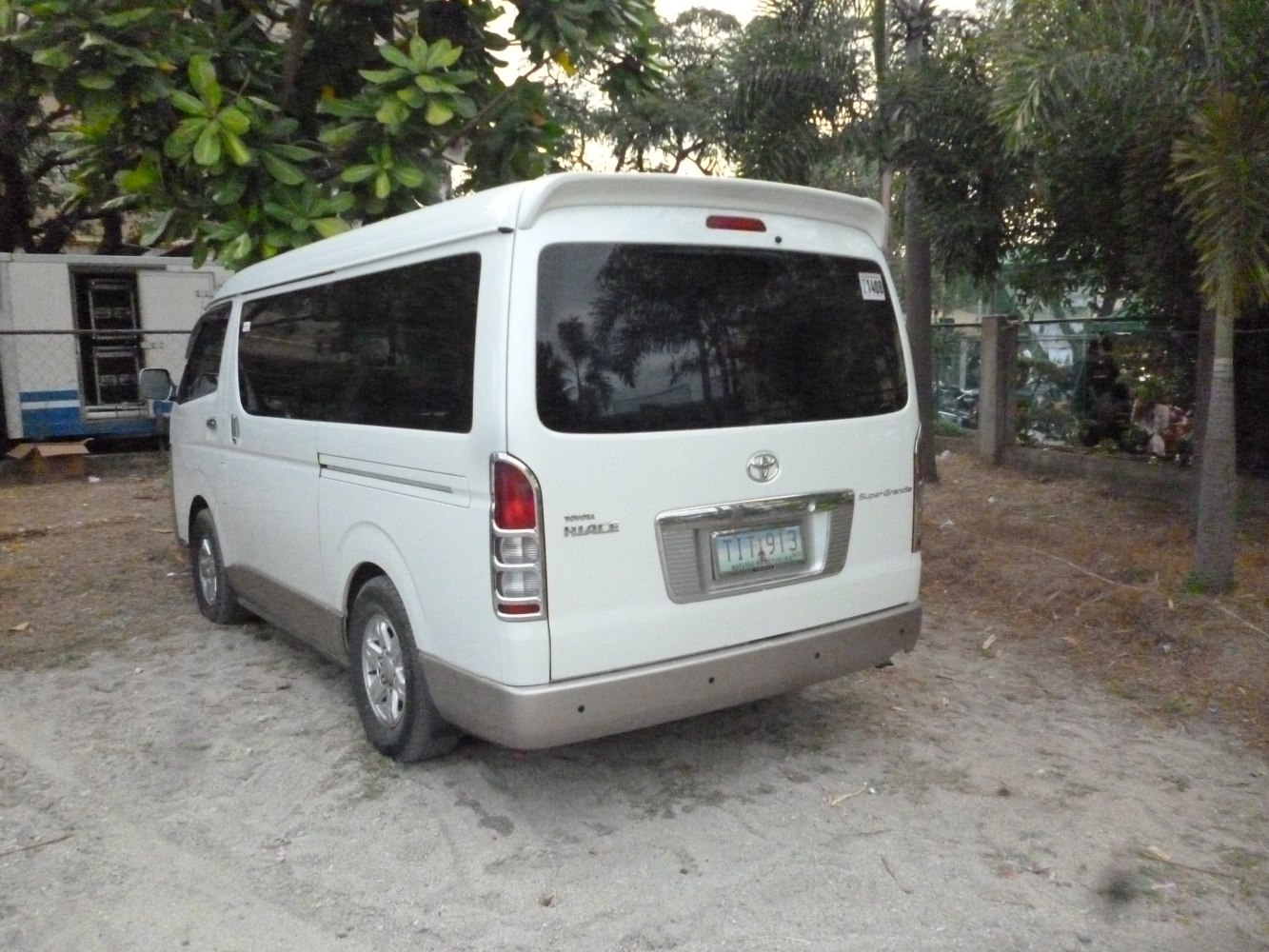Rear view of a long van with large tinted window and vertical taillights