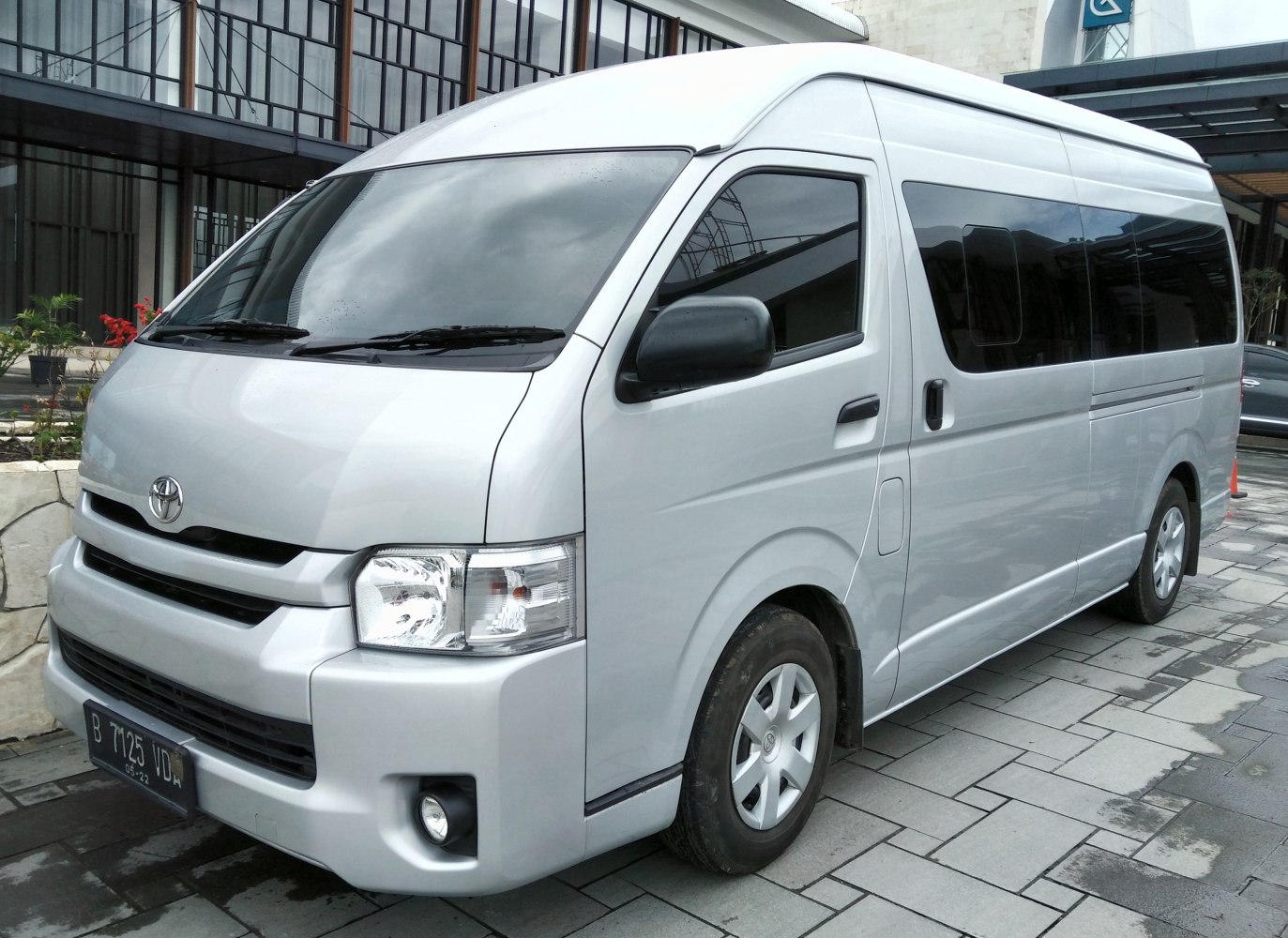 Silver high-roof passenger van with tinted windows, front side view