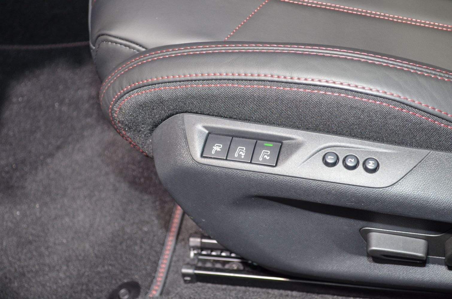 Electric seat adjustment and memory controls with red-stitched fabric seat edge