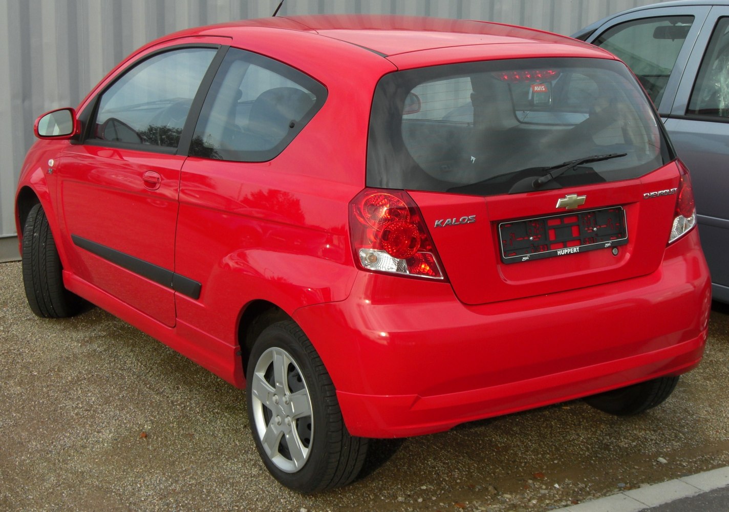 Red 3-door compact hatchback rear view with taillights and alloy wheels