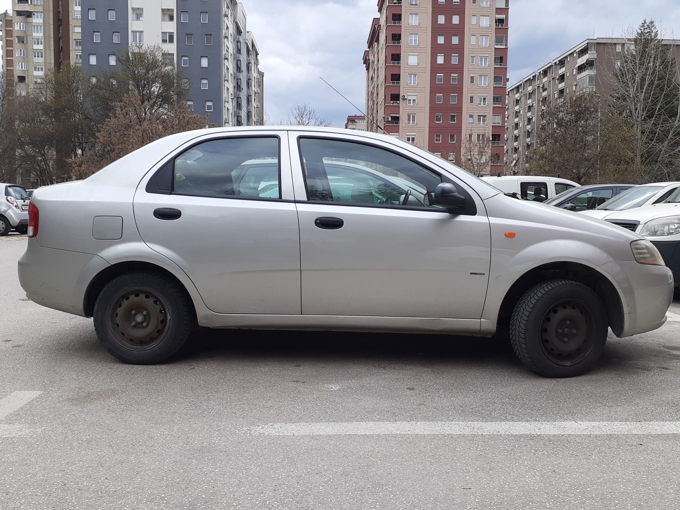 Side view of a silver 4-door sedan with steel wheels.