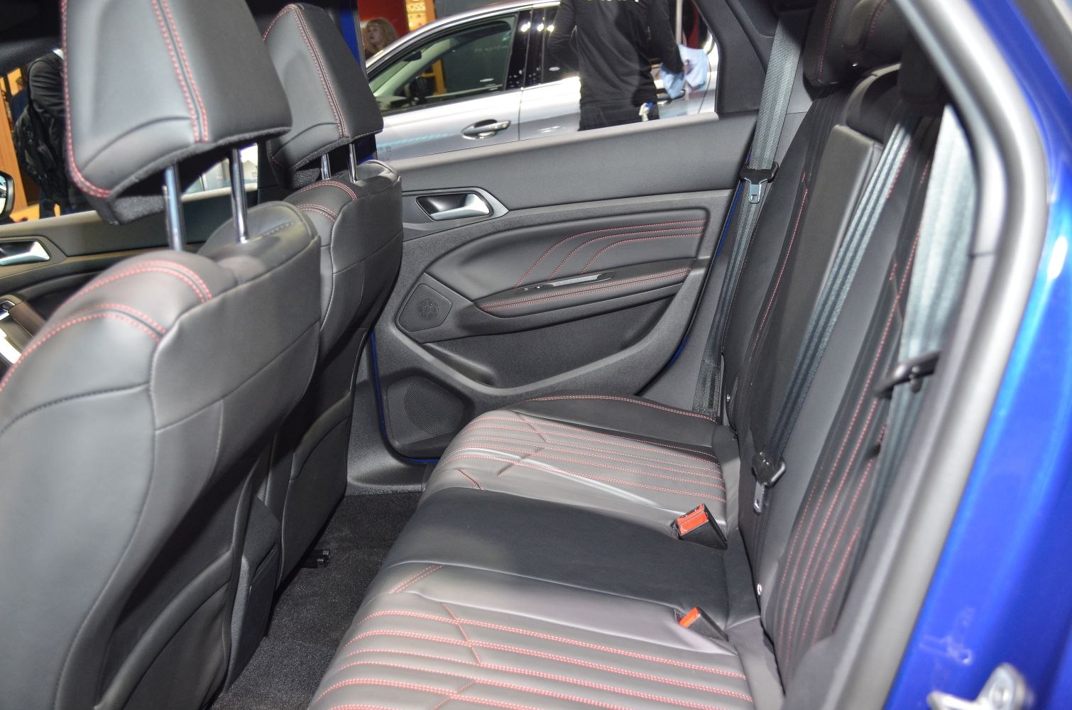 Black leather rear seats with red stitching and rear door panel