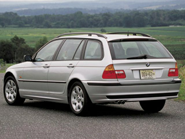 Rear side view of a silver estate with roof rails and dual exhaust