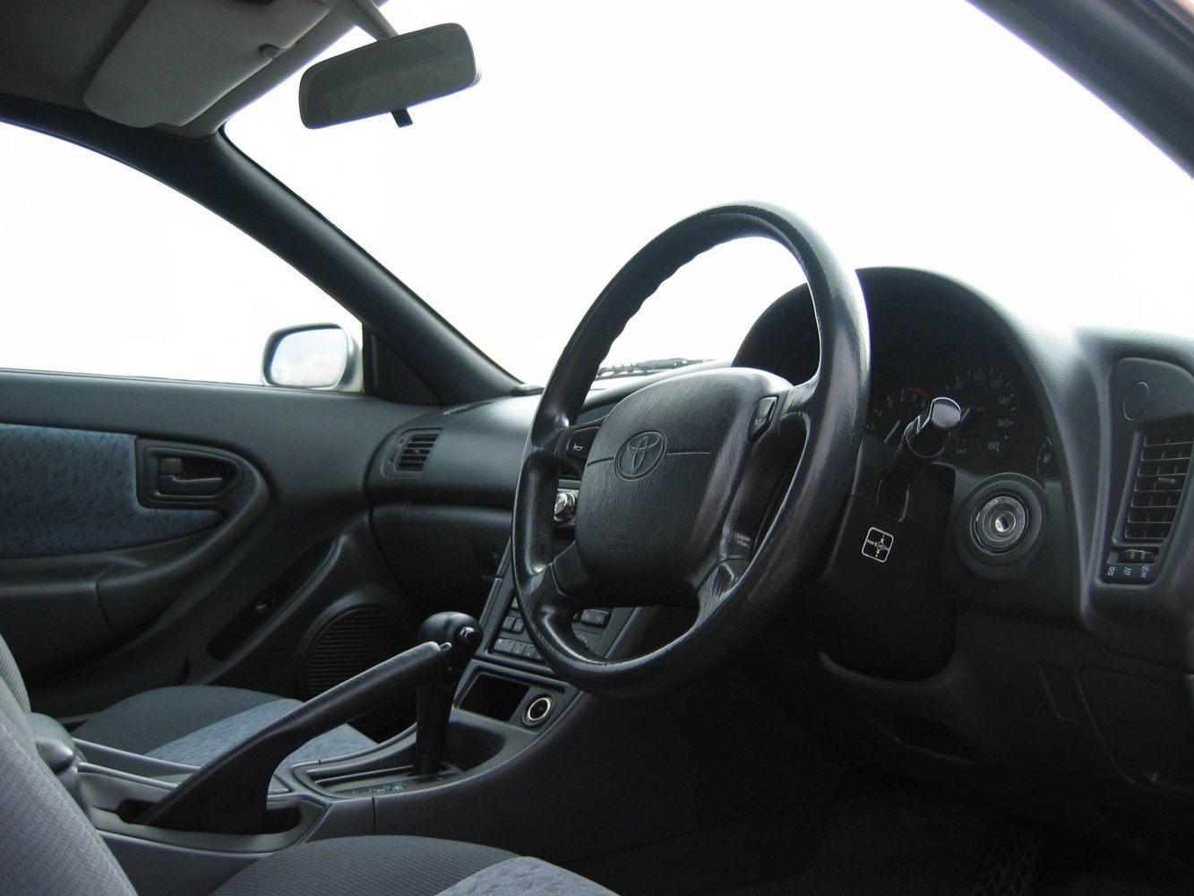 Interior with steering wheel, manual gear shift, and dashboard