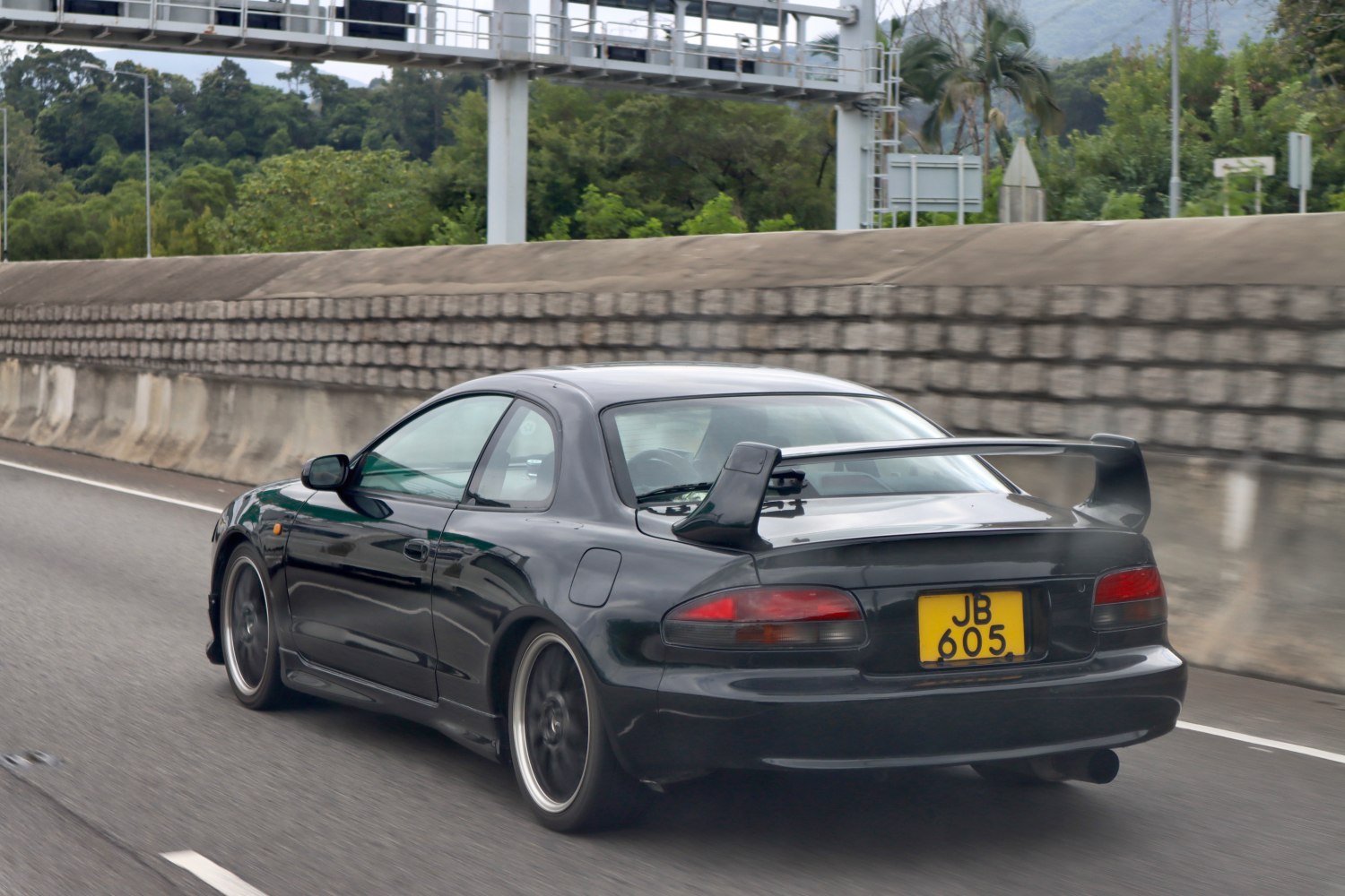 Rear view of a black coupe with large rear spoiler