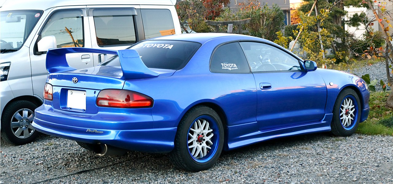 Blue coupe with large rear spoiler and custom alloy wheels
