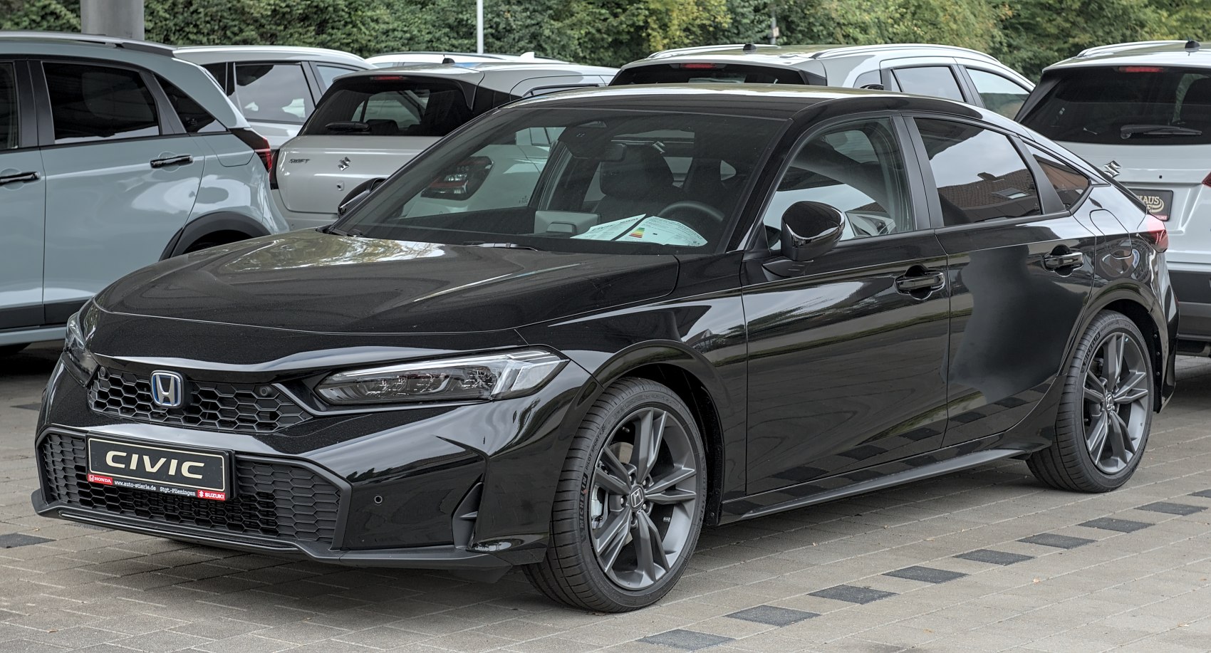 Sleek front and side view of a modern hatchback with sporty wheels and sharp headlights.