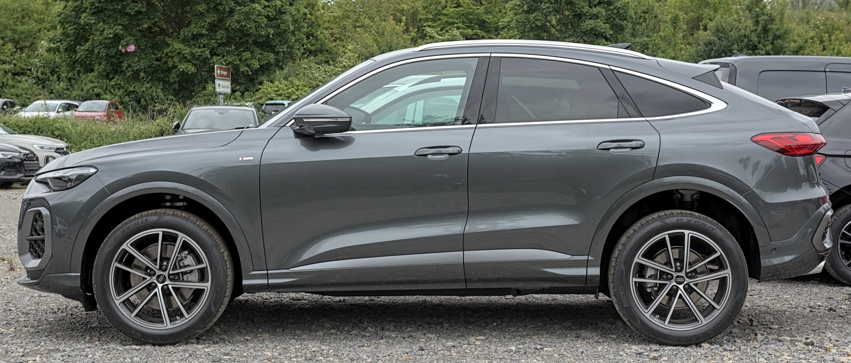 Side view of a sleek modern SUV coupe with sporty 5-spoke alloy wheels.