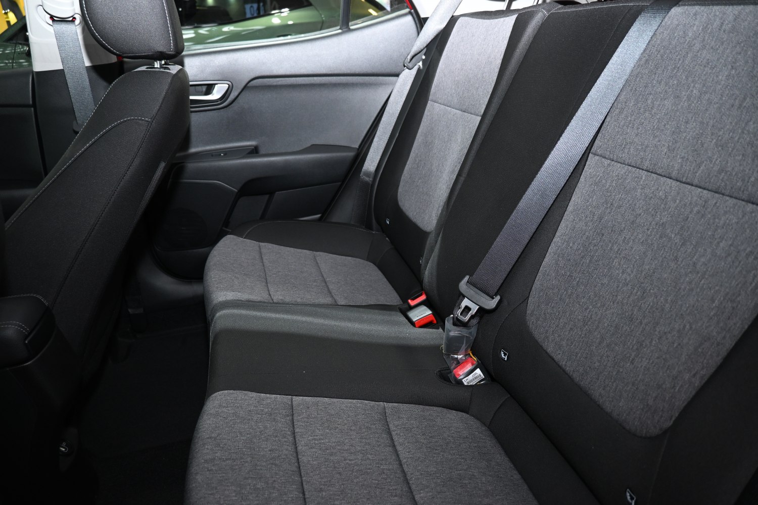 Rear seat interior with fabric upholstery and integrated seat belts
