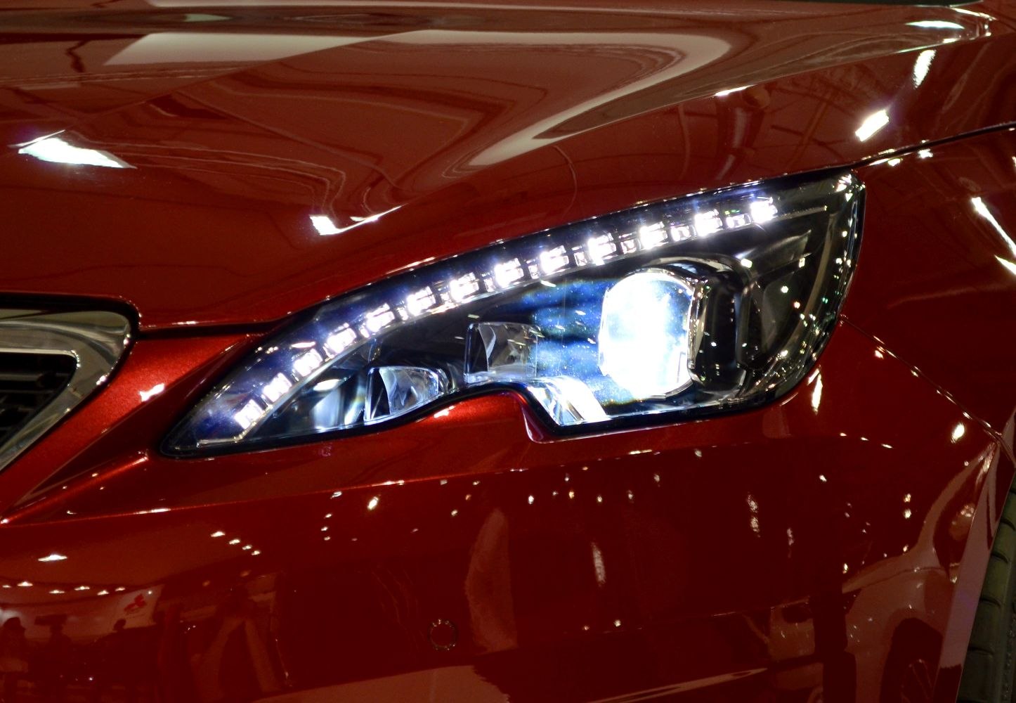 Close-up of car front headlight with LED strip and projector lamp