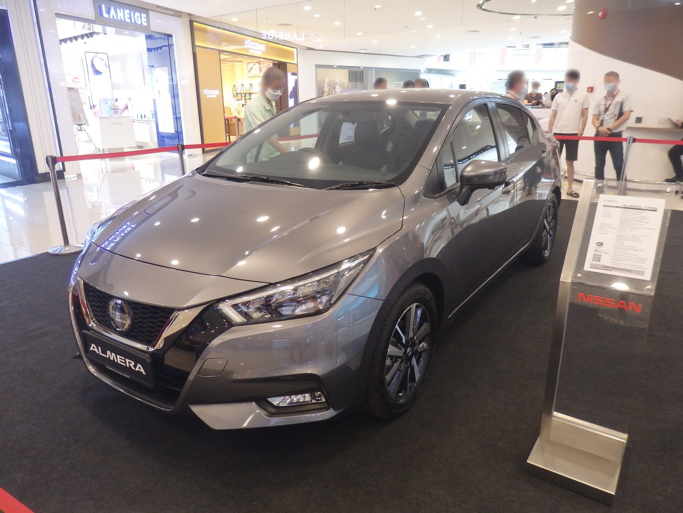 Sleek front 3/4 view with headlights and alloy wheels in showroom