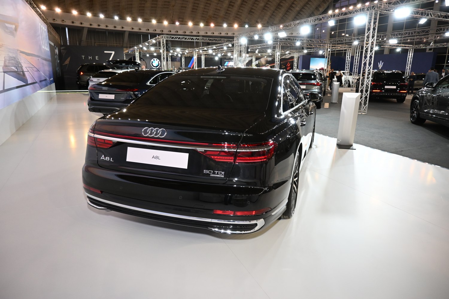 Rear view of a black luxury sedan with LED tail lights and dual exhaust pipes.
