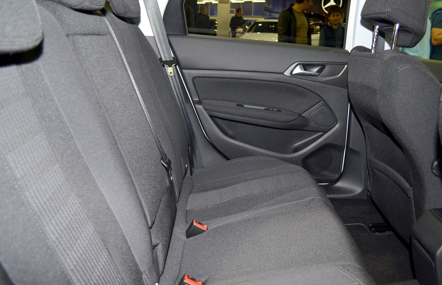 Rear seat and door panel interior with fabric upholstery and seatbelts.