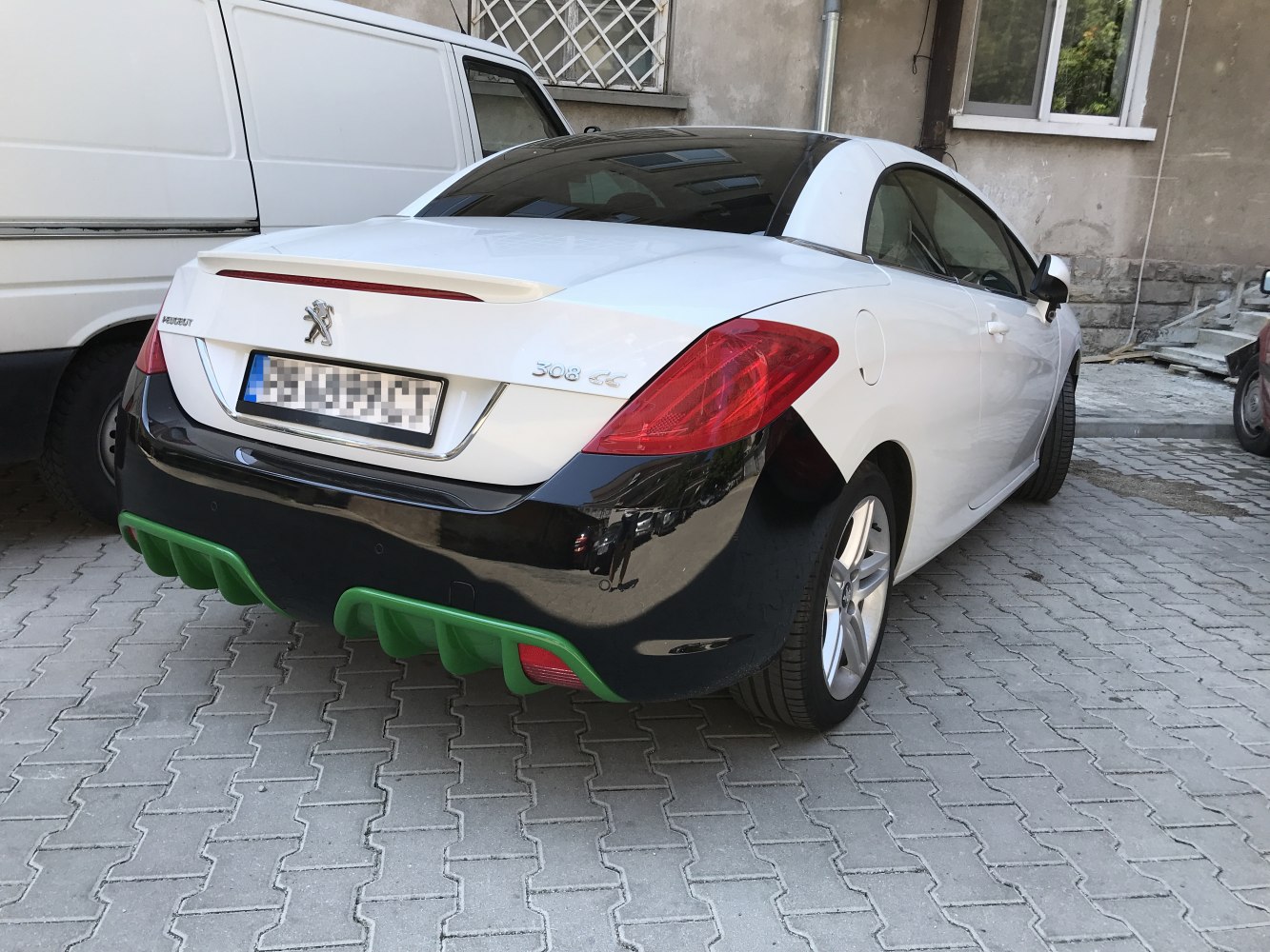Rear of a convertible with black bumper and green diffuser