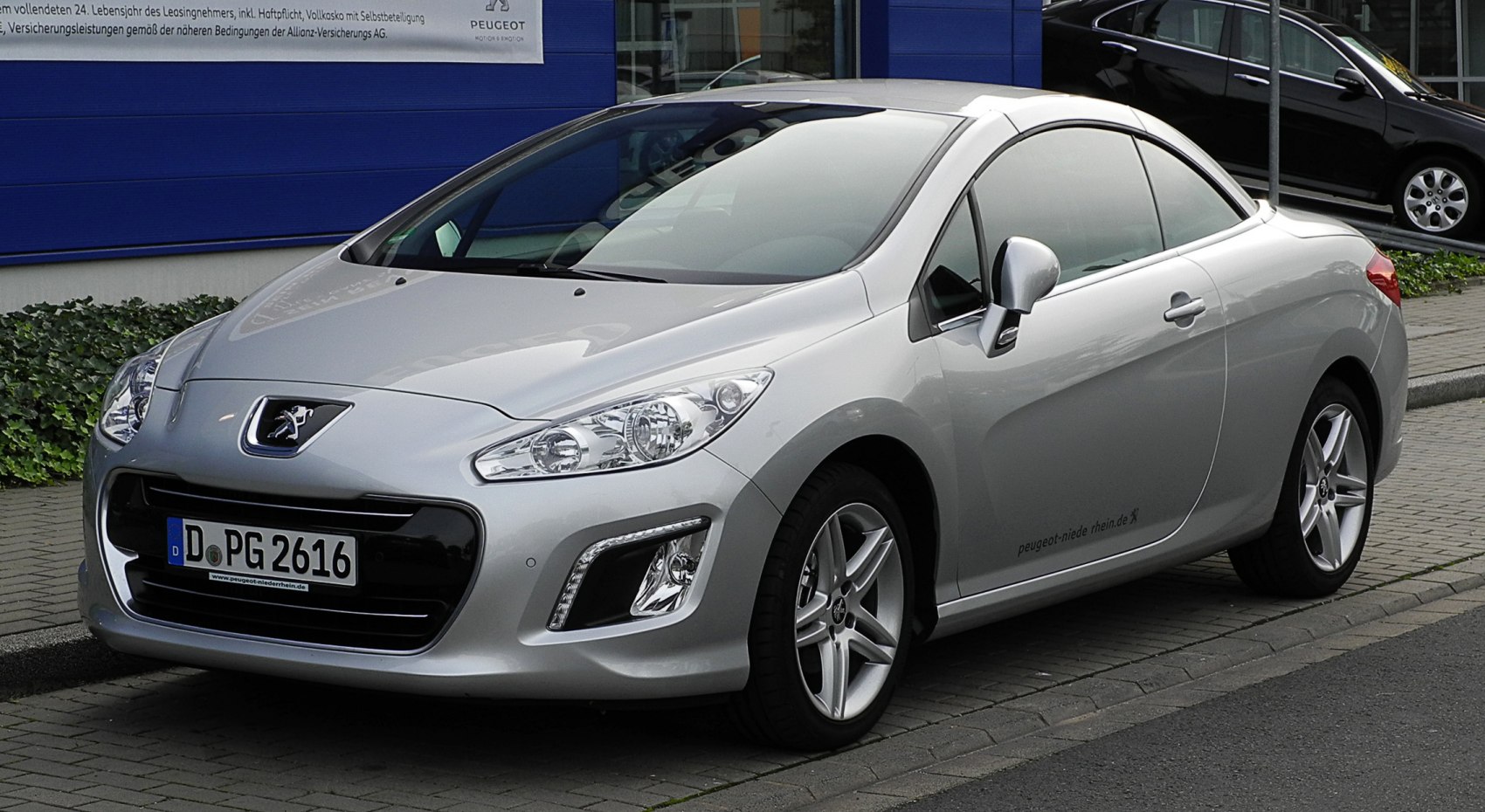 Silver convertible coupe front side with modern headlights and alloy wheels