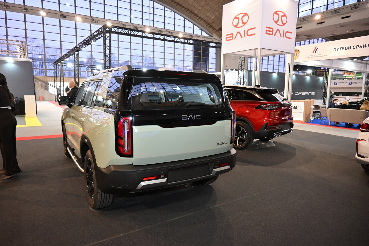 Rear view of SUV with vertical tail lights and two-tone black and beige paint.