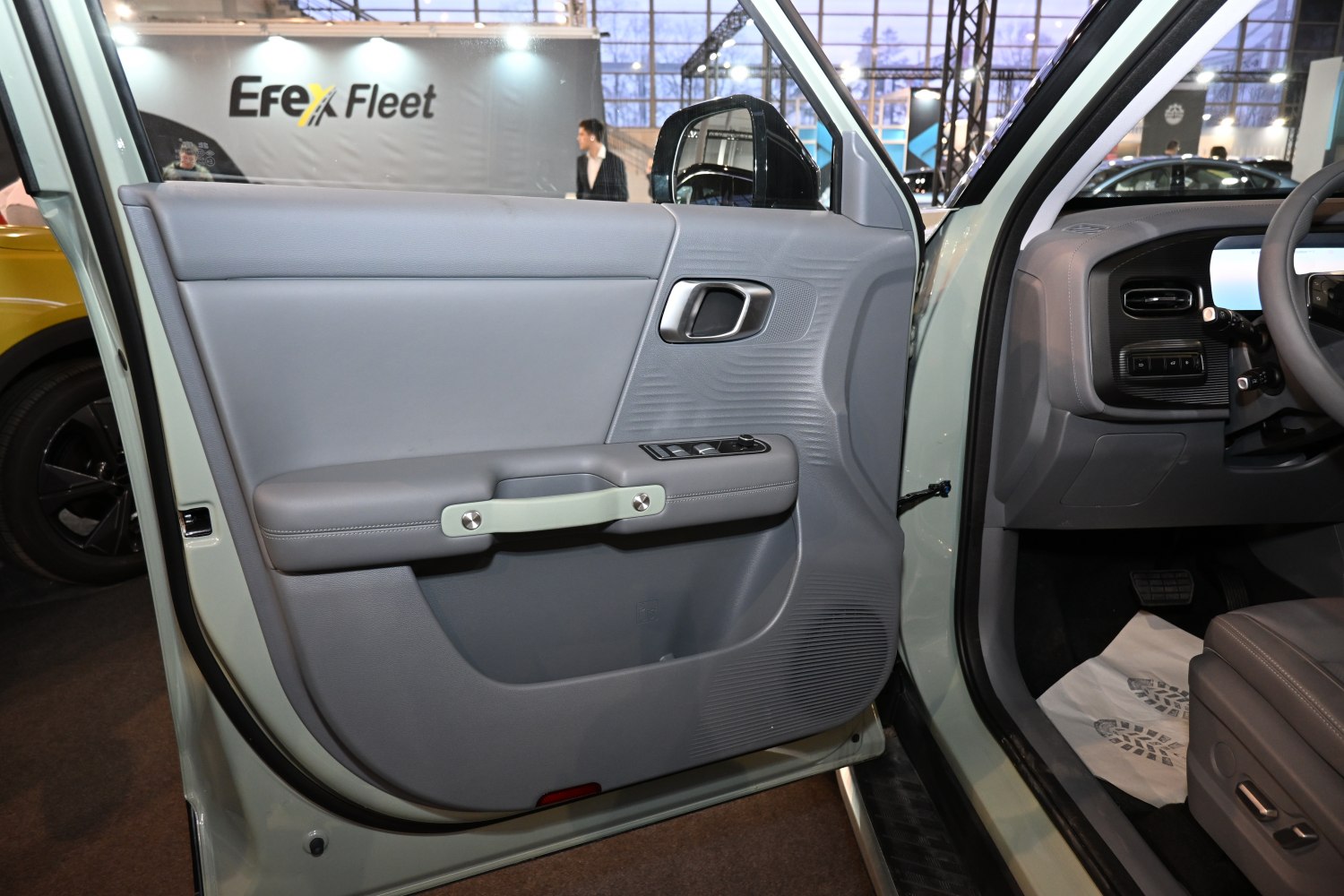 Close-up of a car's interior door panel with handle and control buttons