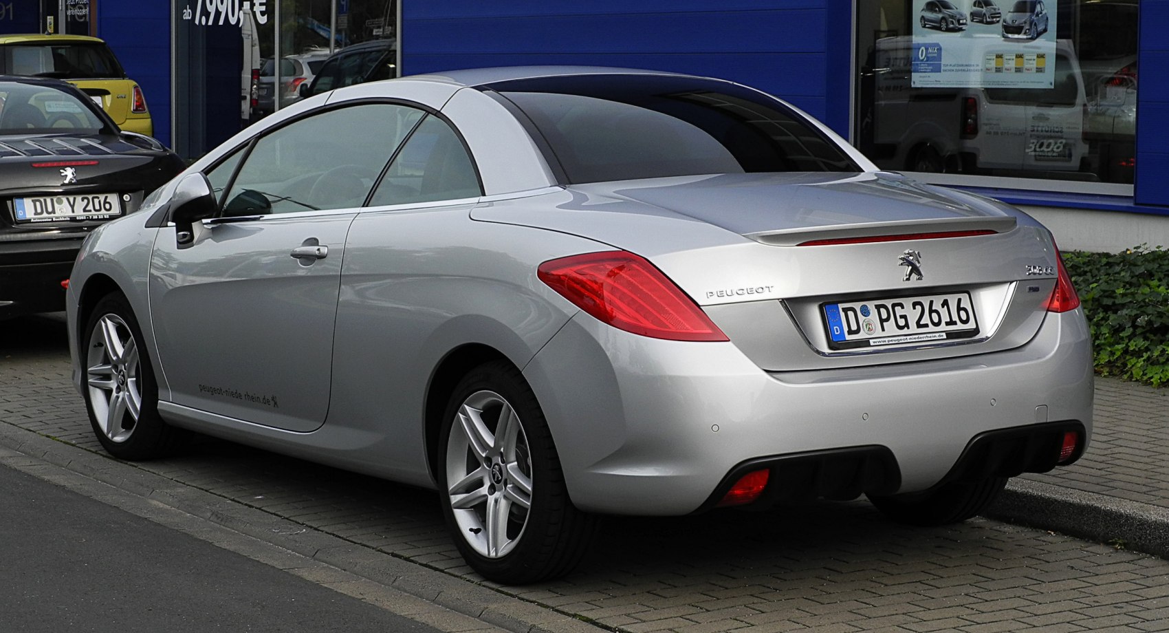 Rear side view of silver convertible with alloy wheels and hardtop roof