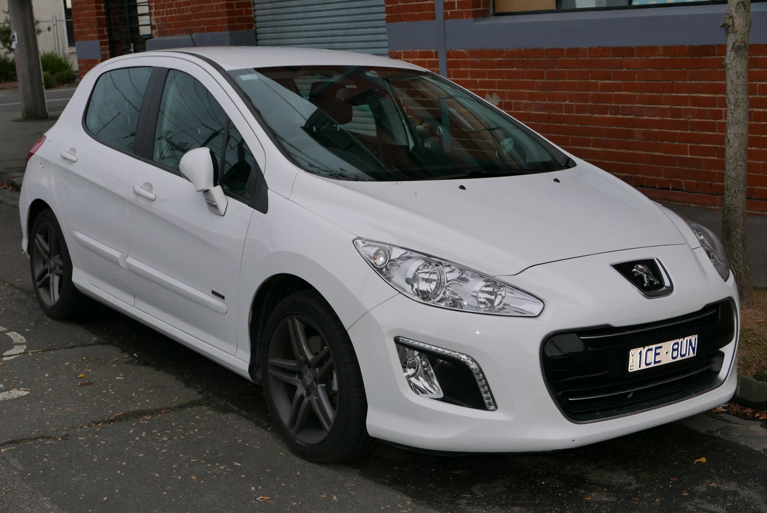 White hatchback front view with distinctive headlights and grille.