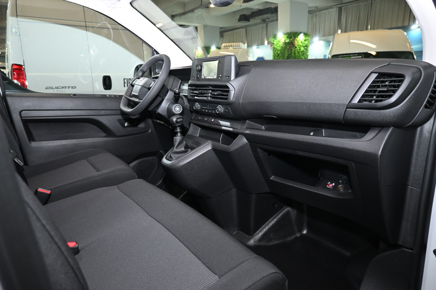 Spacious and functional van interior with modern dashboard and manual transmission.