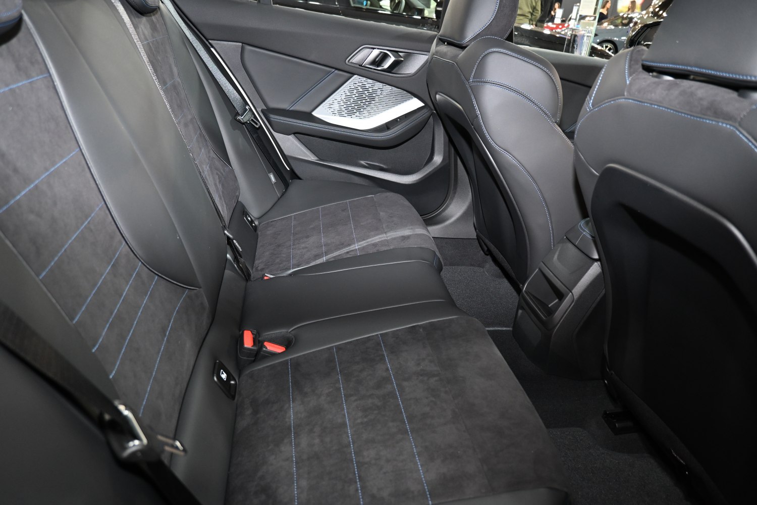 Rear seat interior with leather and suede upholstery and blue stitching