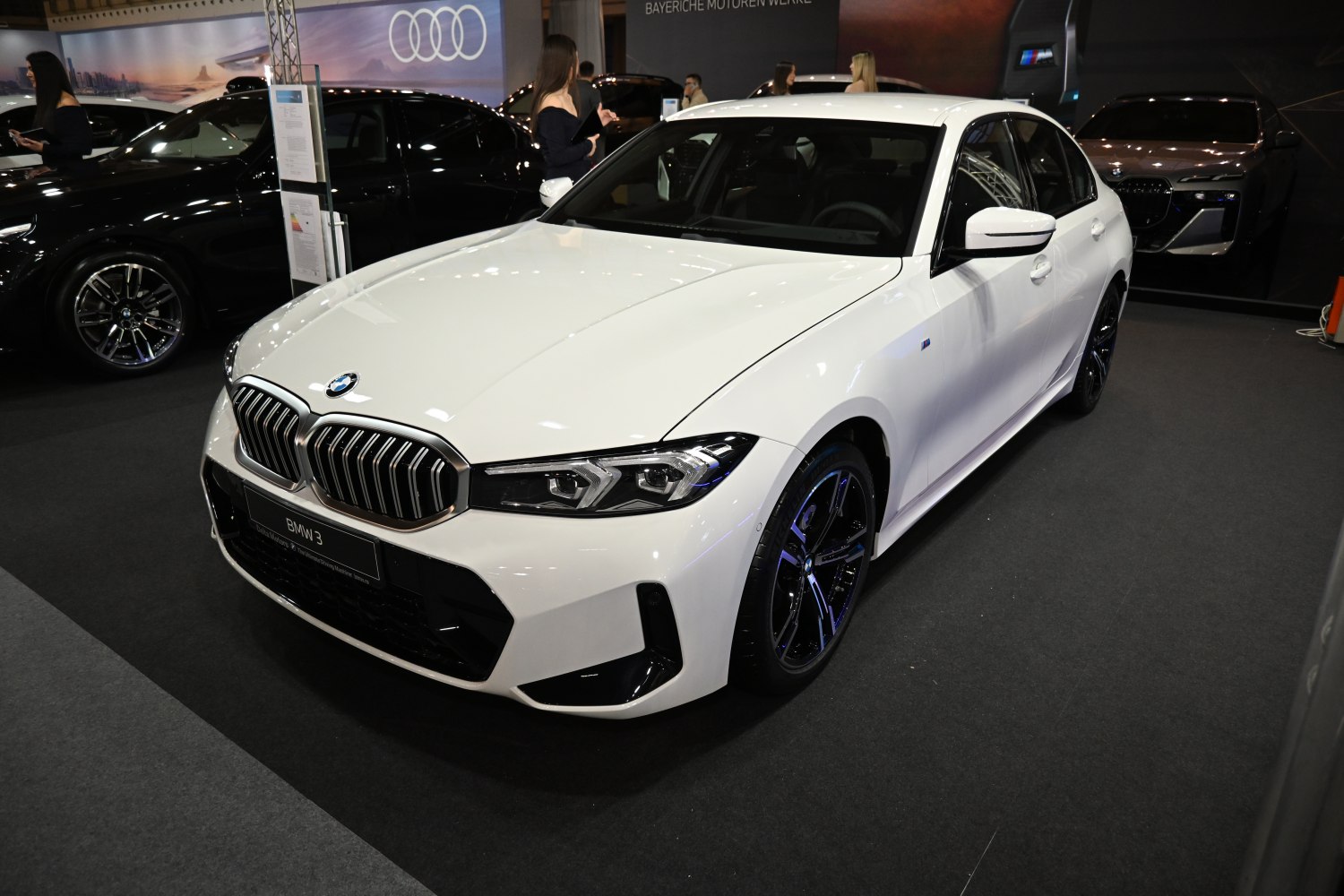 Prominent kidney grille and sharp LED headlights on a white sedan